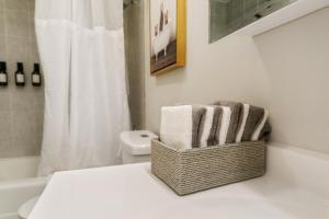 a bathroom with a basket of towels on a counter at USS Alexandria in Highwood +24 photos
