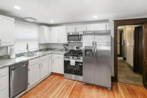 a kitchen with white cabinets and stainless steel appliances at USS Maddox in Libertyville