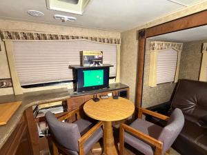 a small dining room with a table and a television at Camper Adventure in Livingston
