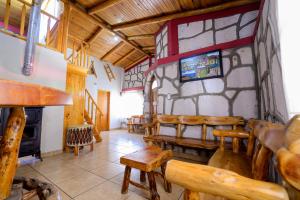 a living room with a fireplace and wooden chairs at Cabañas las Gemelas in Areponapuchi