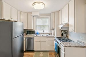 a kitchen with white cabinets and a stainless steel refrigerator at Cozy 2 bed Apt 2 train stops to the Naval Base in Highwood