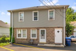a brown brick house with a white door at Cozy 2 bed Apt 2 train stops to the Naval Base in Highwood