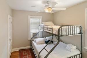a room with two bunk beds and a ceiling fan at Cozy 2 bed Apt 2 train stops to the Naval Base in Highwood