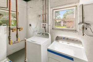 a laundry room with a washing machine and a window at Cozy 2 bed Apt 2 train stops to the Naval Base in Highwood +23 photos