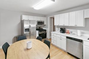 a kitchen with a table and a kitchen with white cabinets at USS Russell in Highwood
