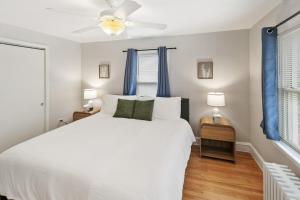 a bedroom with a white bed and blue curtains at USS Russell in Highwood