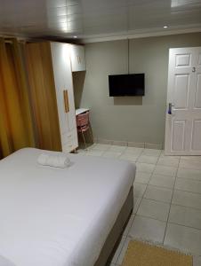 a bedroom with a bed and a tv on the wall at Ashdown BnB in Pietermaritzburg