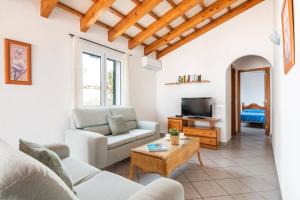 a living room with a couch and a tv at Villa Maru III by Villa Plus in Cala en Porter