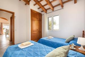 a bedroom with two blue beds and a window at Villa Maru III by Villa Plus in Cala en Porter +14 photos