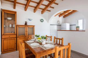 a dining room with a wooden table and chairs at Villa Maru III by Villa Plus in Cala en Porter
