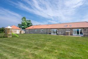 a stone house with a playground in the yard at 3 Bed in nr Beadnell oc-cr1279 in Beadnell