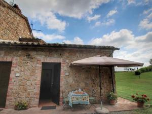 a table with an umbrella in front of a building at Serene Farmhouse in Proceno with Swimming Pool in Proceno