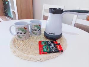 a coffee maker and three coffee cups on a table at Apartman Stella Banja Luka in Krndija +7 photos