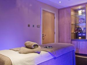 a purple bedroom with a bed with a towel on it at 2 Bed in Saltash oc-87705 in St. Mellion +17 photos