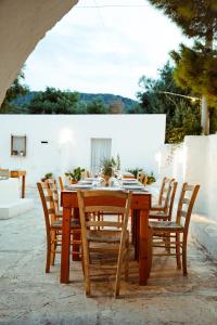 a wooden table with wooden chairs and a table and chairsearcher at Masseria Mozzone in Fasano