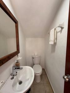 a bathroom with a white toilet and a sink at VISTAMAR Casa a pie de Playa in Playa Agua Blanca