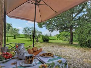 a table with food on it with an umbrella at Rustic Stone Farmhouse in Proceno in Proceno