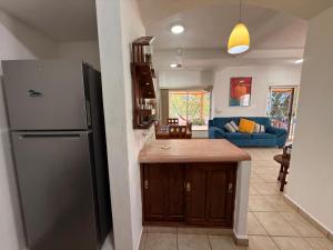 a kitchen with a refrigerator and a living room at VISTAMAR Casa a pie de Playa in Playa Agua Blanca +20 photos