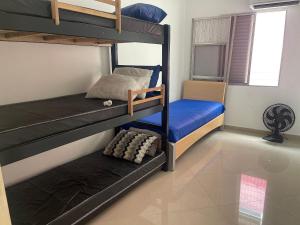 a bedroom with two bunk beds and a chair at Apto no Canto do Forte com garagem in Praia Grande