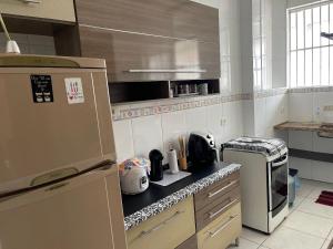 a kitchen with a counter top with a refrigerator at Apto no Canto do Forte com garagem in Praia Grande +5 photos