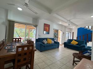 a living room with blue couches and a table at VISTAMAR Casa a pie de Playa in Playa Agua Blanca