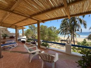 a patio with chairs and a view of the beach at VISTAMAR Casa a pie de Playa in Playa Agua Blanca