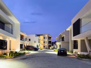 a car parked in a parking lot between two buildings at Executive Cozy Suite at THE HIDDEN DOMUS I Saltpond Suite in Madina