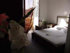 a bedroom with a bed and a vase of flowers at Hotel Grand Royal Cairo in Cairo