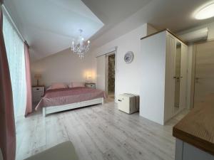a bedroom with a bed and a chandelier at Gold Horse Vendégház in Szilvásvárad +43 photos