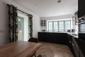 a kitchen with a wooden table and a dining room at Sunray Cottage in Weymouth