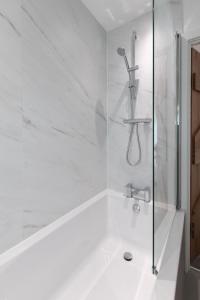 a white bathroom with a shower and a sink at Sunray Cottage in Weymouth +33 photos