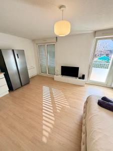 a living room with a bed and a television at Appartement cosy à 10 min de Strasbourg - Bischheim in Bischheim