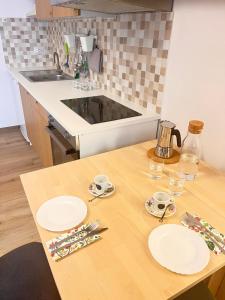 a kitchen with a wooden table with plates on it at casa vacanza La Palma Rossa Taranto in Taranto +56 photos