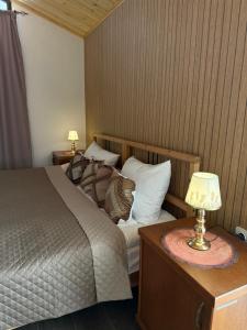 a bedroom with a bed and a table with a lamp at Sant House Dilijan in Dilijan