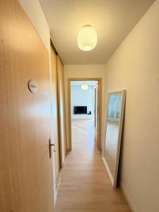 an empty hallway with a door and a mirror at Appartement cosy à 10 min de Strasbourg - Bischheim in Bischheim