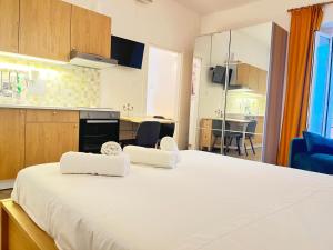 a large white bed in a room with a kitchen at casa vacanza La Palma Rossa Taranto in Taranto