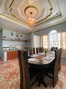 a dining room with a table with chairs and a chandelier at AJM Iligan Homestay in Saray