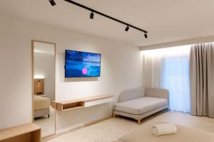 a white room with a chair and a mirror at Thinalos Hotel in (( Saoúli )) +4 photos