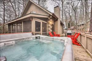a hot tub on a deck next to a house at Sunrise Hideaway on Cherry Log Mountain in Blue Ridge