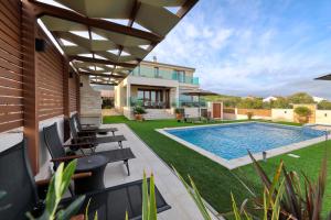 a backyard with a swimming pool and a house at Masanda in Ždrelac