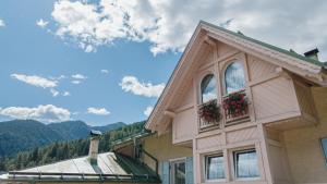 ein Haus mit zwei Fenstern, die mit Blumen verziert sind in der Unterkunft Hotel Pangrazzi - 3 stelle superior in Fucine