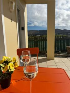 a table with two wine glasses on a orange table at Europe's last sunset in Waterville