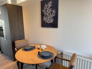 a dining room with a wooden table and chairs at Kustgeluk-Luxe aan Zee, splinternieuw appartement in het hart van Koudekerke in Koudekerke