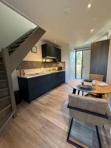 a kitchen and dining room with a table and a staircase at Kustgeluk-Luxe aan Zee, splinternieuw appartement in het hart van Koudekerke in Koudekerke