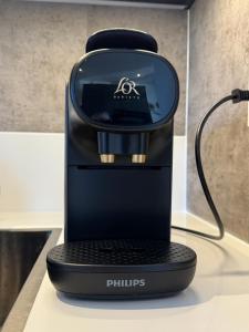 a black coffee maker on a table at Kustgeluk-Luxe aan Zee, splinternieuw appartement in het hart van Koudekerke in Koudekerke