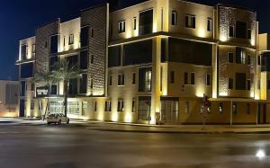 an empty parking lot in front of a building at night at Smayah Residence Hotel in Riyadh
