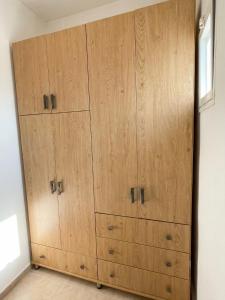 a large wooden cabinet in a room with a window at White Emerald in Haifa