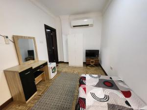 a bedroom with a bed and a sink and a mirror at Shahan Residence in Muscat