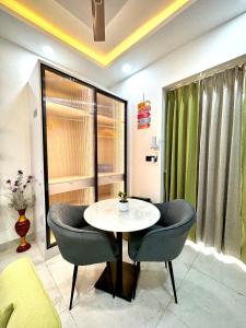 a dining room with a table and two chairs at Lux Lettings in Noida +5 photos