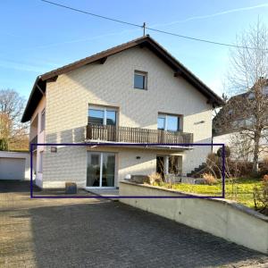 a house with a balcony on the side of it at Eifeeloft - Eifel erleben in Neroth